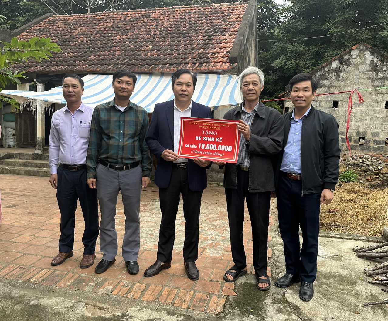 Đồng chí Trịnh Văn Thể, Ủy viên BTV Huyện ủy, Phó Chủ Tịch HĐND huyện, trao tiền hỗ trợ mua bê sinh kế cho gia đình ông Nguyễn Tiến Diện.