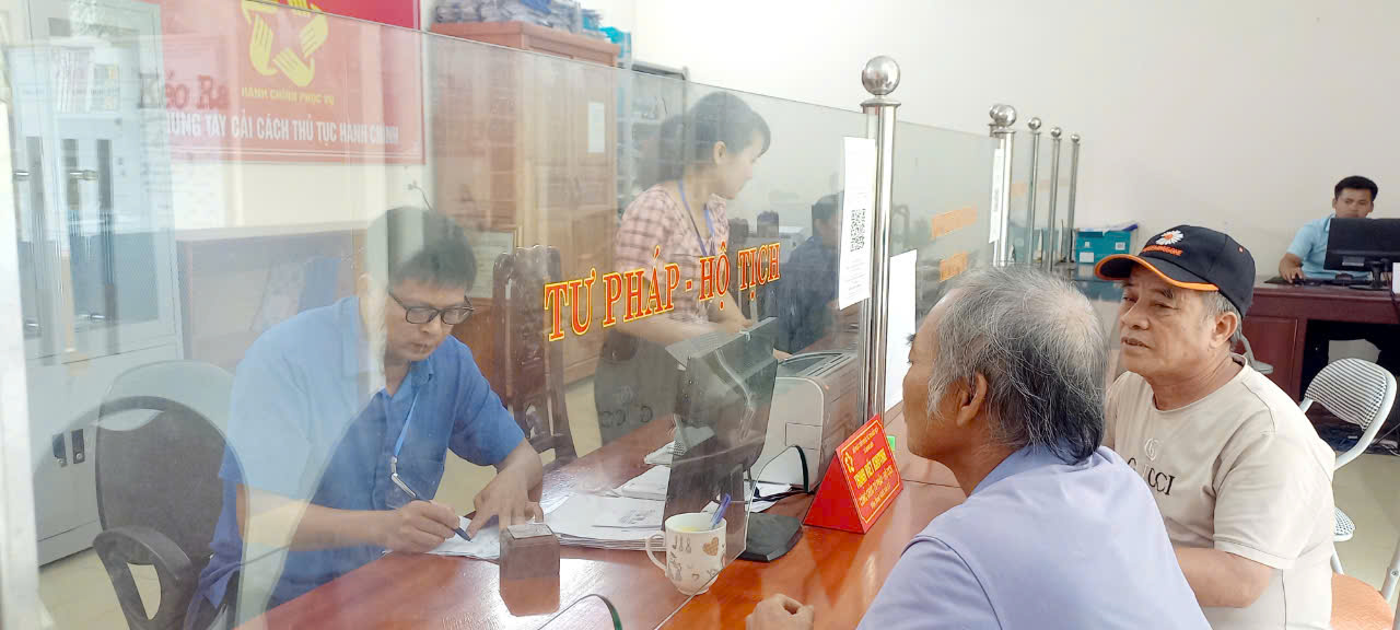 Cán bộ bộ phận 1 cửa xã Định Liên hướng dẫn người dân ứng dụng chuyển đổi số trong thực hiện thủ tục hành chính.